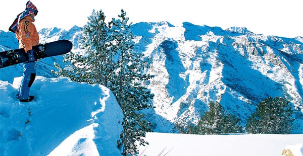 Snowboarder standing on a cliff