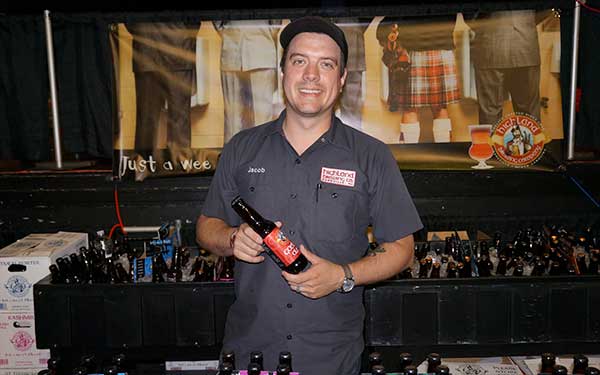 Highland Brewing Rep poses with bottle of Gaelic Ale