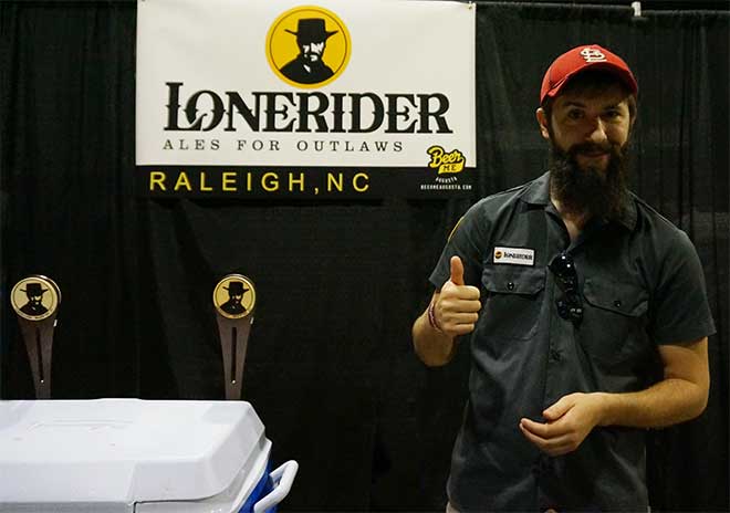 Lonerider rep poses with thumbs up next to kegerators