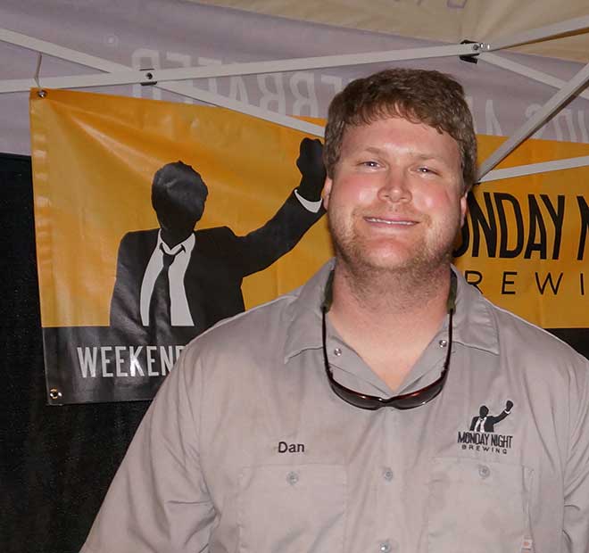 Monday Night Brewing rep Dave poses for photo in front of brewery banner