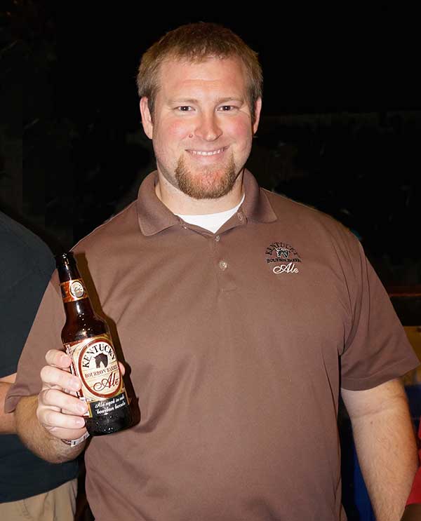 Alltech Kentucky Bourbon Ale Rep poses with bottle of Bourbon Barrel Ale