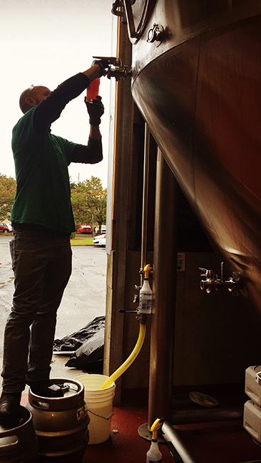 Hemphill samples Saison Rouge from the tank. (Courtesy: Red Hare Brewing Co.)