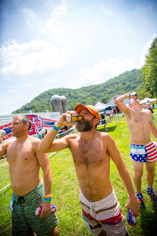 Three shirtless dudes chugging Oskar Blues beer