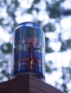 A can of Terrapin Sound Czech Pilsner prominently positioned on the edge of a porch railing.