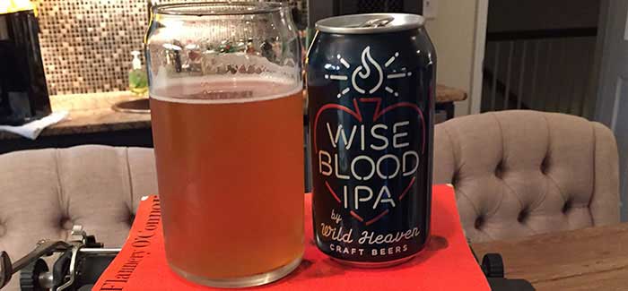 Wild Heaven Wise Blood IPA can and glass atop orange O'Connor novel