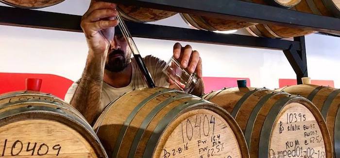 Brewer samples barrel aged beers.