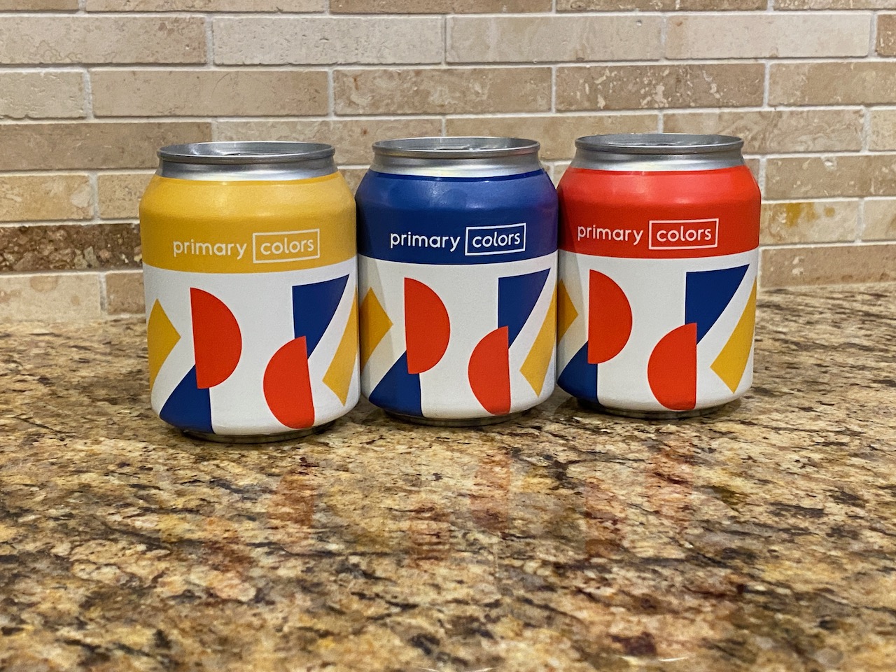 Three eight-ounce cans by Primary Colors Brewing.