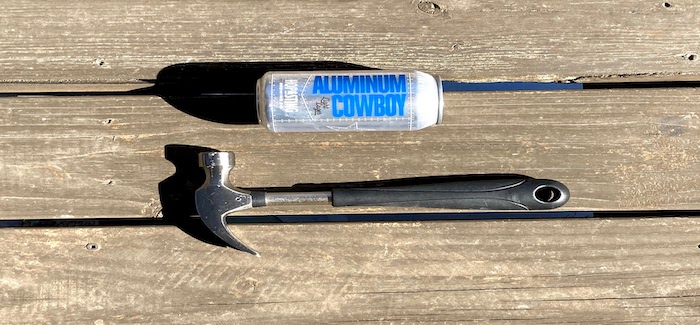 A can of Aluminum Cowboy beer lying next to a hammer