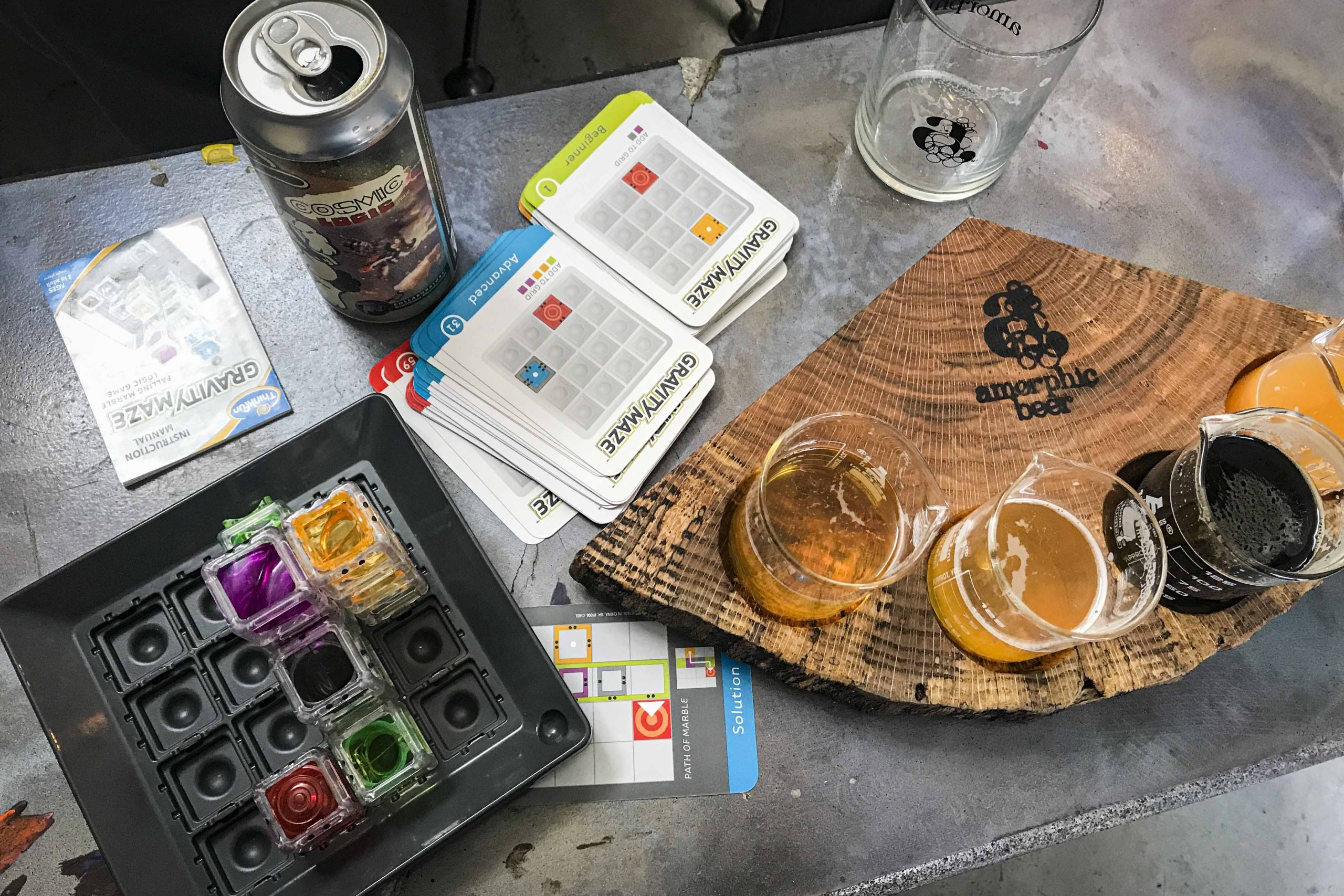 Brain games and a flight of beers sit atop a concrete table