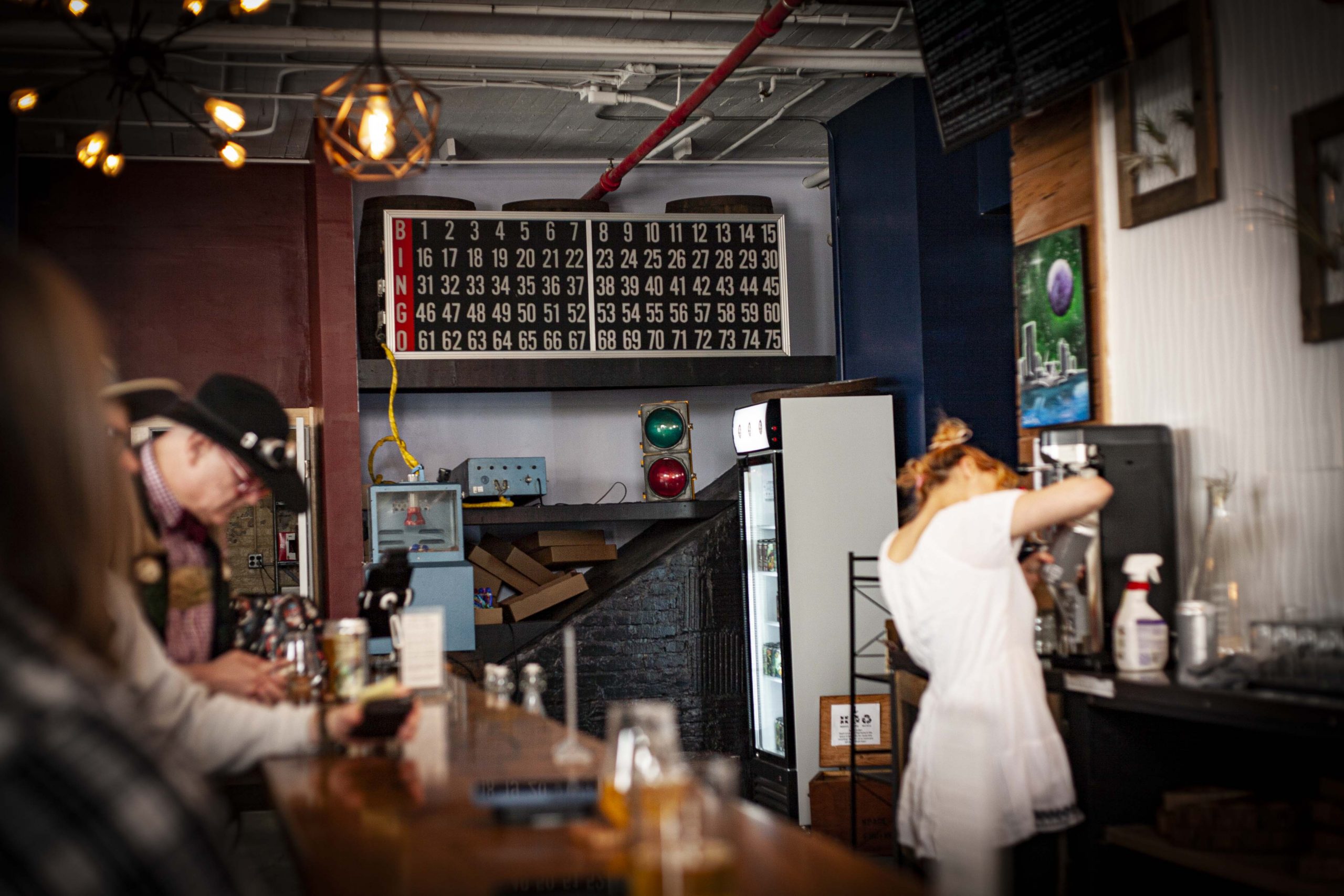 A retro, vacuum-drawn BINGO machine and light board behind a busy bar of beer drinkers