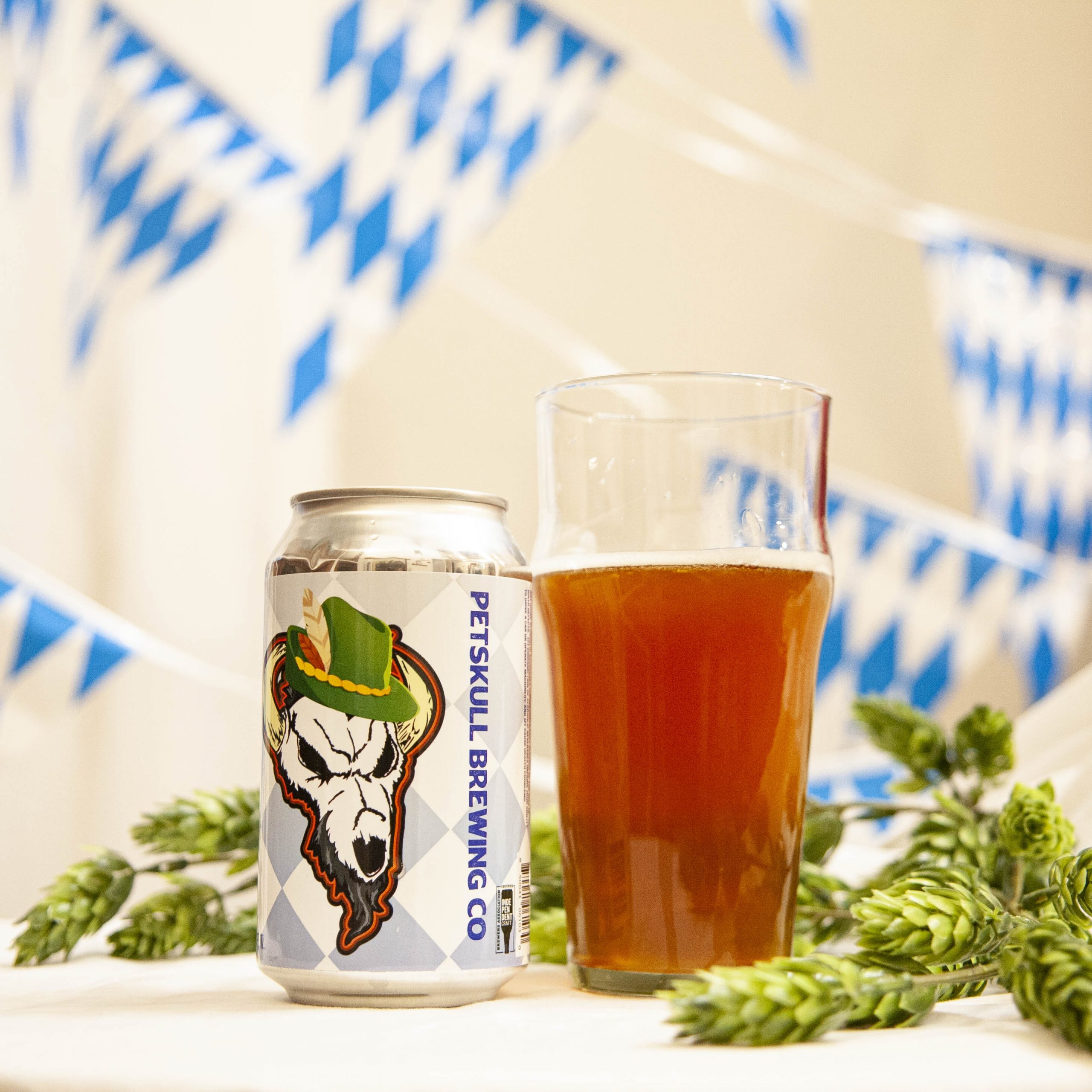 PetSkull's Hofftoberfest lager is poured into a nonick pint glass, amidst hop cones and white and blue bunting.