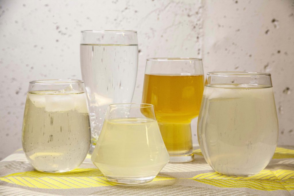 A variety of hop water in glassware, showing the variety in color and clarity. 
