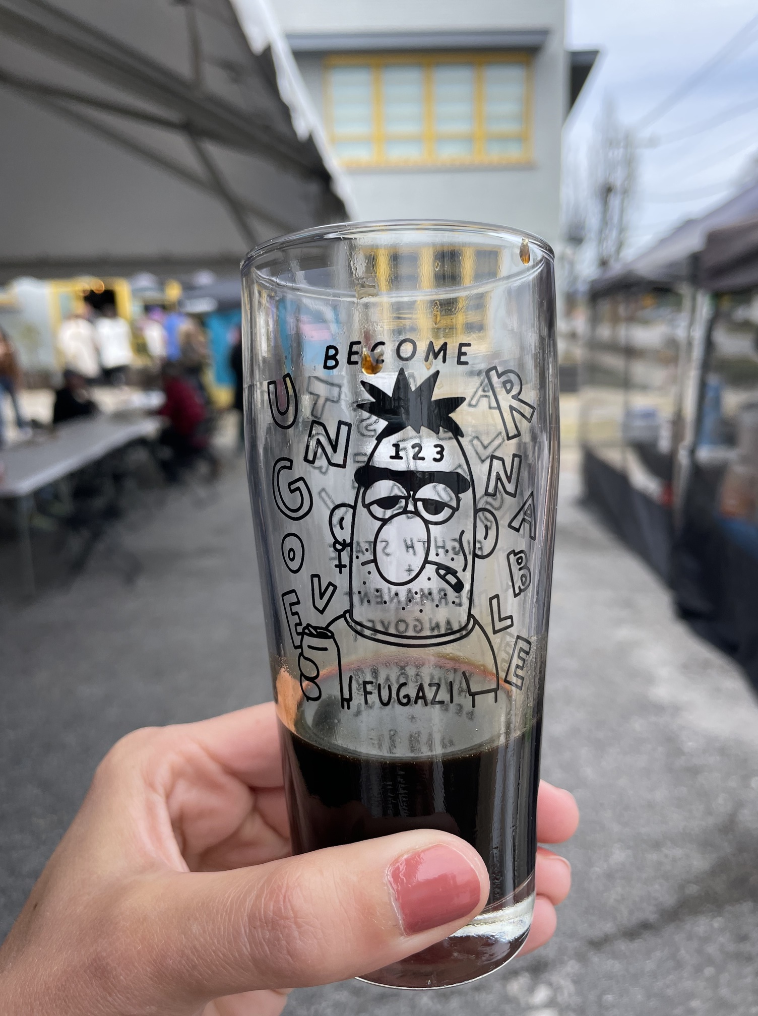 A photo of a commemorative glass from the Altered States Volume II festival. It is approximately one-third full of a dark beer.