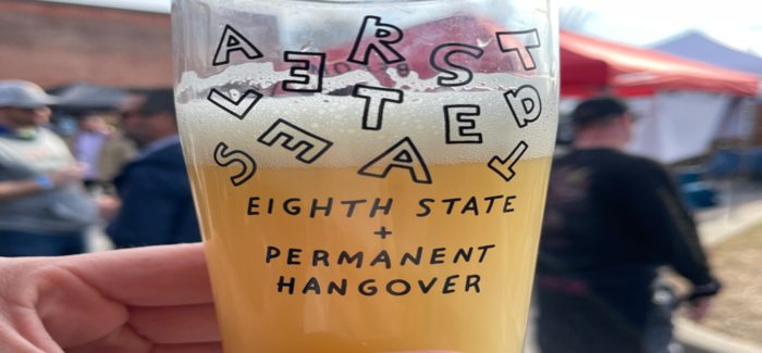 A photo of a commemorative glass from Altered States, about three-quarters full of beer.